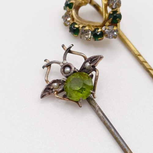 623 - A silver coloured metal, seed pearl and green stone stick pin, in the form of a fly, and a white and... 