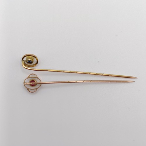 621 - An early 20th century yellow metal and red stone stick pin, and an early 20th century, yellow metal ... 