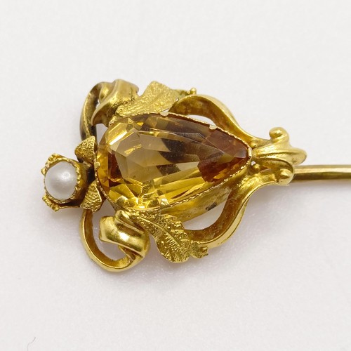 615 - An Art Nouveau style yellow metal and brown stone stick pin Provenance:  From a single owner collect... 