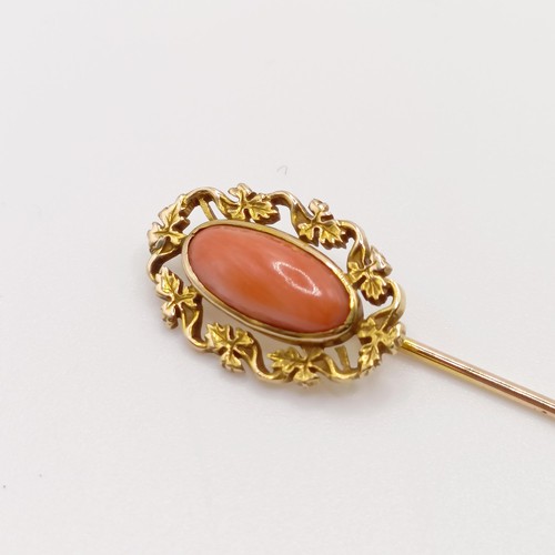 614 - A late 19th/early 20th century yellow metal and coral stick pin  Provenance:  From a single owner co... 