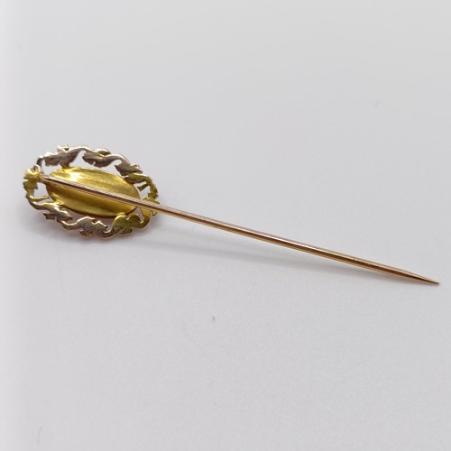 614 - A late 19th/early 20th century yellow metal and coral stick pin  Provenance:  From a single owner co... 