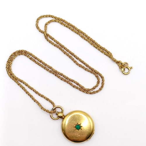 668 - A 9ct gold and green stone locket, on a yellow metal chain