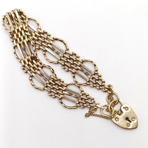 665 - A yellow metal bracelet, with a padlock clasp