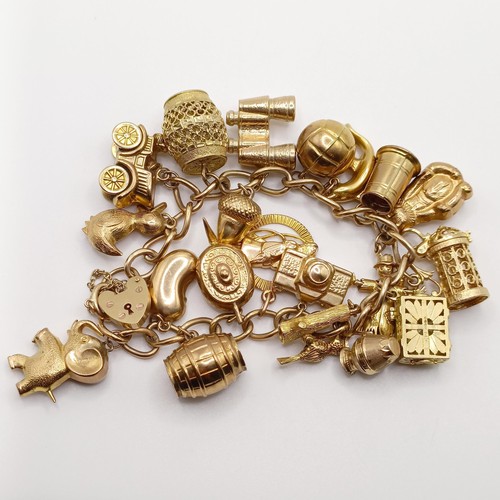 698 - A 9ct gold charm bracelet, with assorted gold and yellow metal charms, all in 52.5g