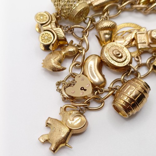 698 - A 9ct gold charm bracelet, with assorted gold and yellow metal charms, all in 52.5g