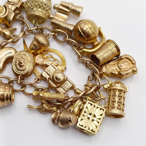 698 - A 9ct gold charm bracelet, with assorted gold and yellow metal charms, all in 52.5g