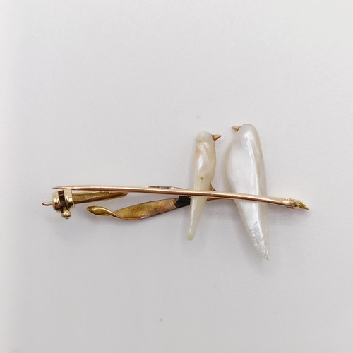 693 - A 1920s yellow coloured metal and mother of pearl bar brooch, in the form of two birds