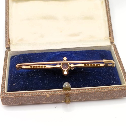 740 - An early 20th century yellow metal, diamond, seed pearl and pink stone bar brooch, lacking one seed ... 