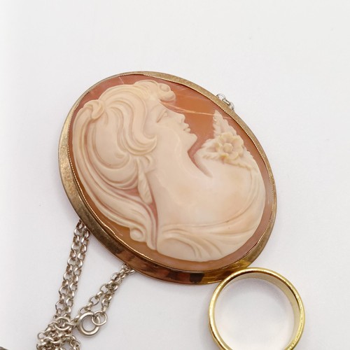 901 - A yellow metal wedding band, ring size P, a cameo brooch, damaged, and a silver locket