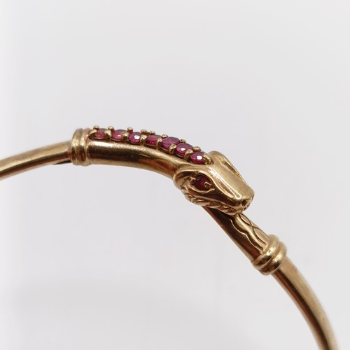 860 - A 9ct gold and ruby bangle, in the form of a serpent, all in 7.2 g