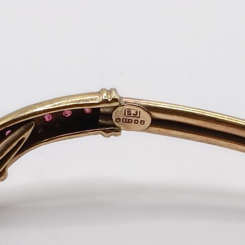 860 - A 9ct gold and ruby bangle, in the form of a serpent, all in 7.2 g