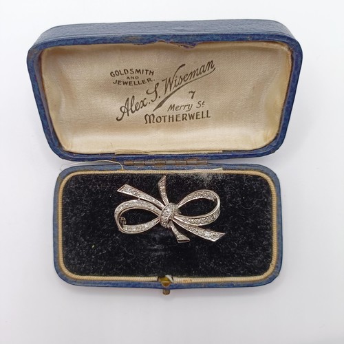 835 - An 18ct white gold and diamond bow brooch, in a vintage jewellery box