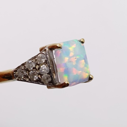 810 - A yellow metal and opal ring, with diamond shoulders, ring size M