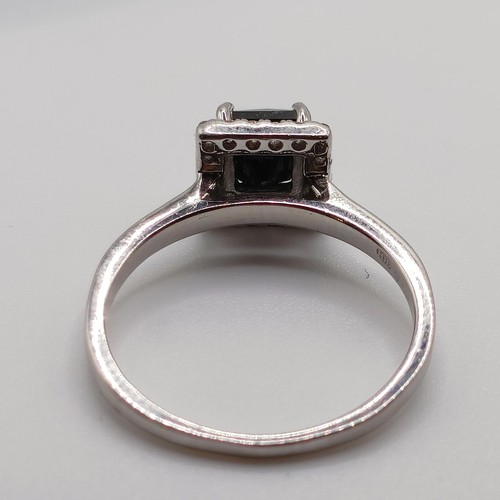 675 - A certificated platinum ring, set with square cut black diamond and a halo of RBC diamonds