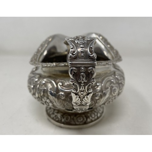 1094 - A George III silver cream jug, crested, with embossed decoration, 8.70 ozt