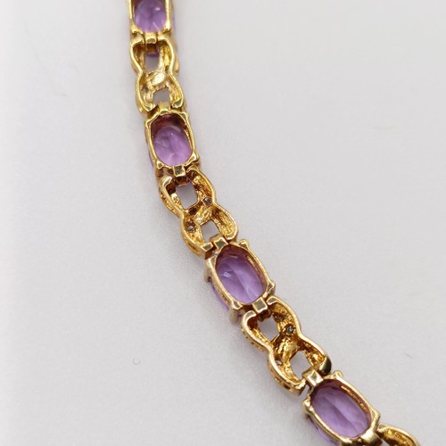 691 - A 9ct yellow gold, amethyst and diamond figure-of-eight bracelet, boxed