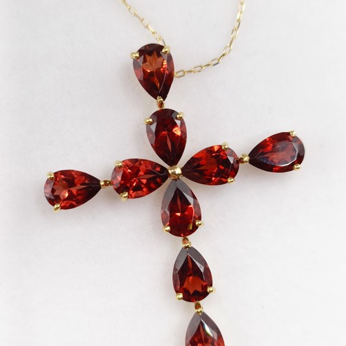 673 - An 18ct yellow gold cross necklace, set with 5.00ct pear shaped garnets, boxed