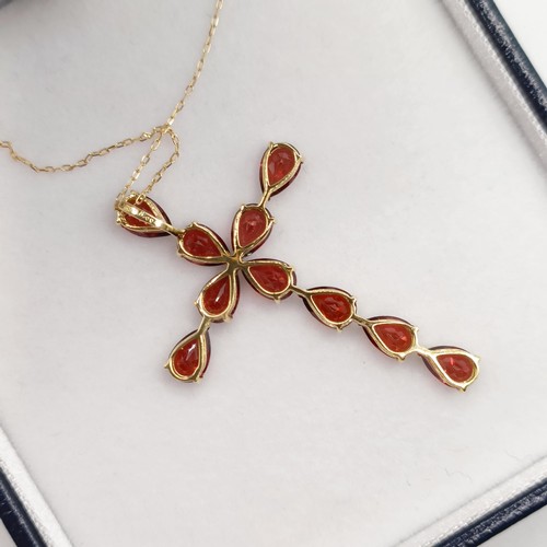 673 - An 18ct yellow gold cross necklace, set with 5.00ct pear shaped garnets, boxed