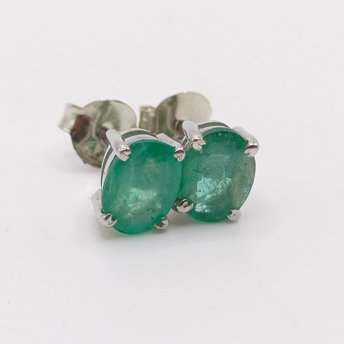 843 - A pair of emerald studs, in silver