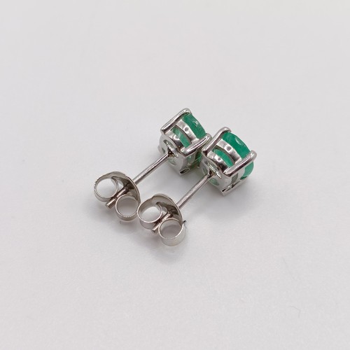 843 - A pair of emerald studs, in silver