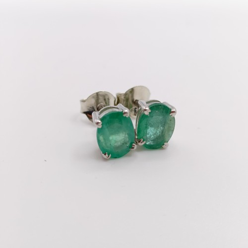 843 - A pair of emerald studs, in silver