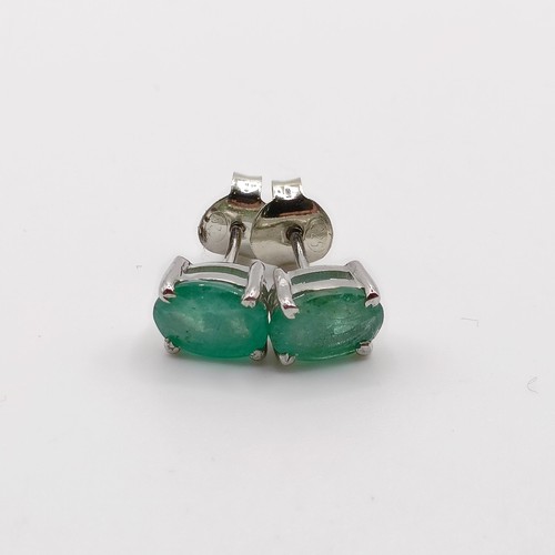 843 - A pair of emerald studs, in silver