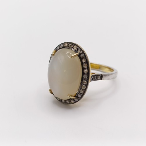 775 - An oval cabochon moonstone and rose-cut diamond ring