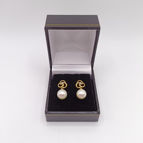 717 - A pair of 9ct yellow gold, round freshwater pearl and diamond pinwheel earrings, boxed