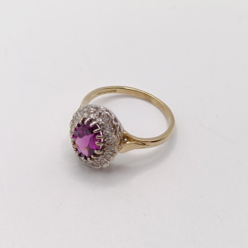 816 - A 9ct yellow and white gold dress ring, set with a purplish red rhodolite garnet, and an R/C diamond... 