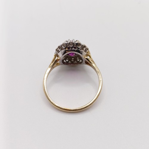 816 - A 9ct yellow and white gold dress ring, set with a purplish red rhodolite garnet, and an R/C diamond... 