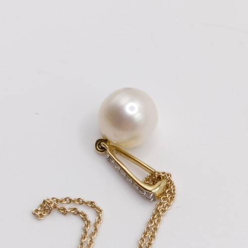 720 - A 9ct yellow gold, round freshwater pearl and diamond pendant, on a 9ct yellow gold chain, boxed