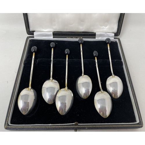 1257 - A George V set of six silver and multi-coloured enamel coffee spoons, with bean handles, cased