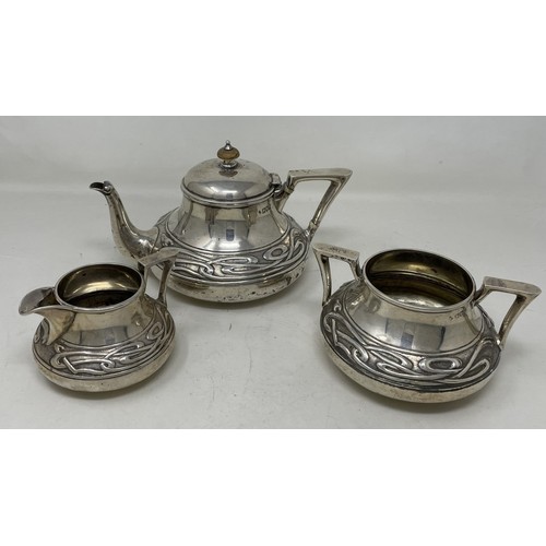 1280 - An Edward VII  Art Nouveau silver three piece tea service, comprising a teapot, sugar bowl and a cre... 