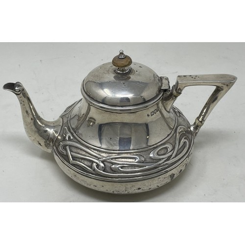 1280 - An Edward VII  Art Nouveau silver three piece tea service, comprising a teapot, sugar bowl and a cre... 