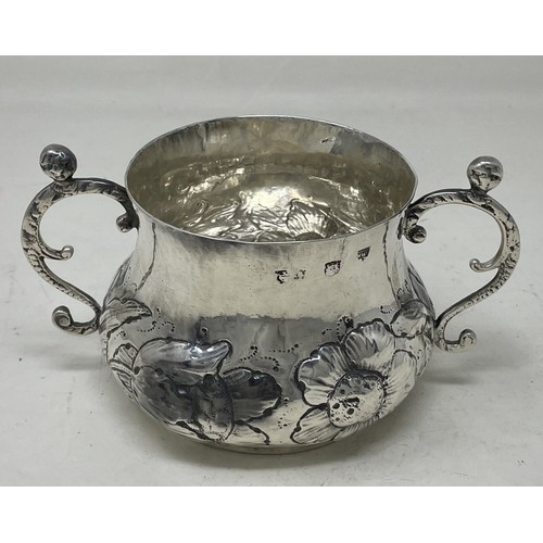 1312 - A 17th century silver porringer, engraved an armorial and with embossed decoration, 16.2 ozt, 16 cm ... 