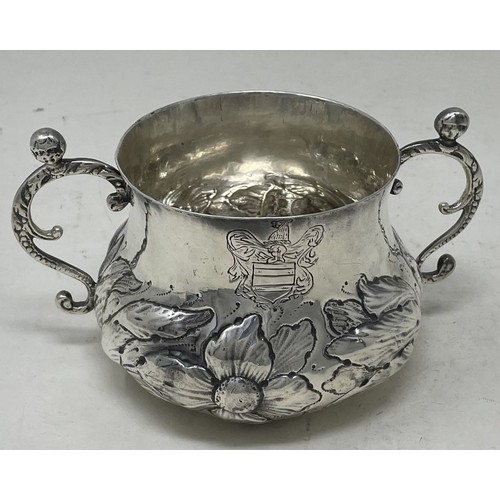 1312 - A 17th century silver porringer, engraved an armorial and with embossed decoration, 16.2 ozt, 16 cm ... 