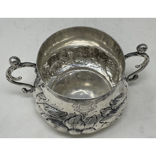 1312 - A 17th century silver porringer, engraved an armorial and with embossed decoration, 16.2 ozt, 16 cm ... 