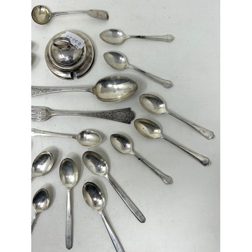 1345 - A group of assorted silver tea and coffee spoons, a silver lid, and a silver christening fork and sp... 