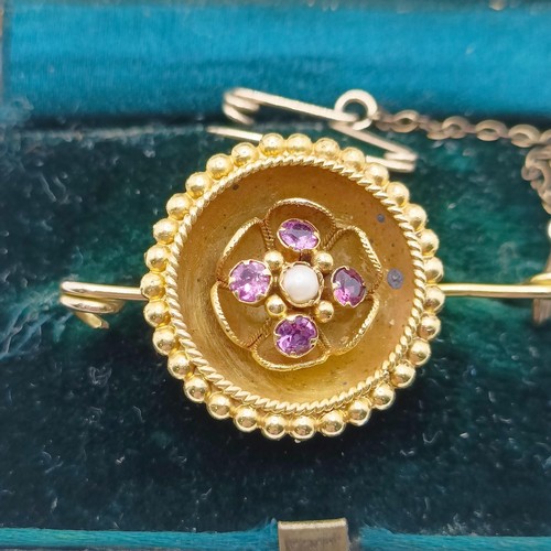 744 - A yellow coloured metal, seed pearl and purple stone bar brooch, in a vintage jewellery box