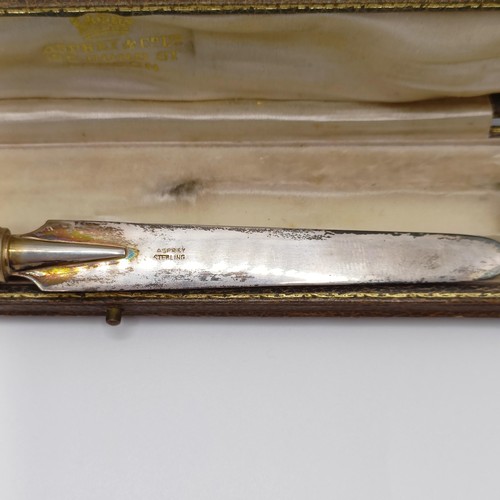 868 - A 1920s yellow and silver coloured metal and blue enamel paperknife, in a fitted case, retail mark f... 