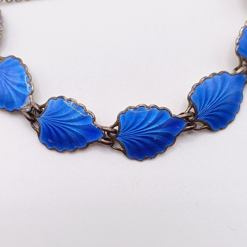 948 - A silver coloured metal and blue enamel bracelet, the links in the form of leaves