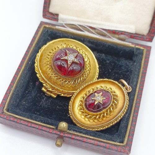 949 - A late 19th/early 20th century yellow metal cabochon cut red stone and diamond brooch, and a matchin... 