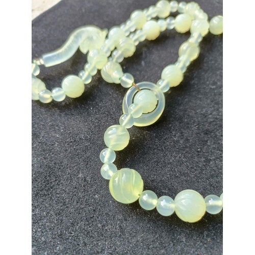 973 - A Chinese light greenstone necklace, and a bead necklace (2)