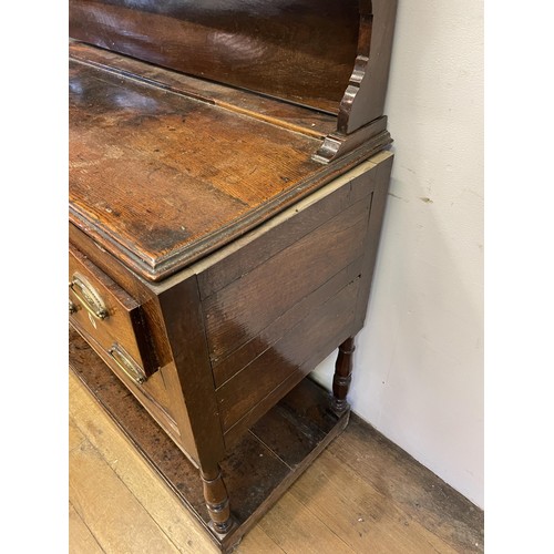 1593 - An 18th century oak dresser, with a three tier plate rack, on a base with five drawers above an unde... 