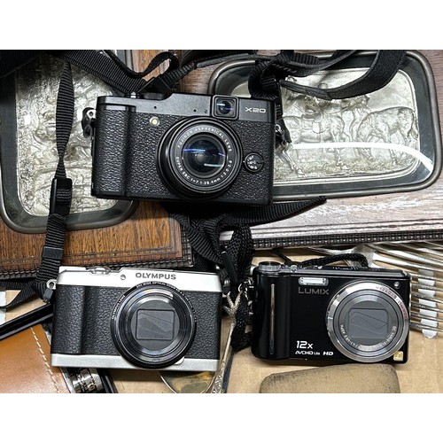 1512 - A Fujifilm X20 camera, an Olympus Optical 5-Axis IS camera, another camera, a pair of silver coloure... 