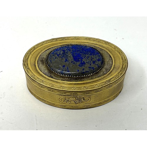 1521 - A gilt metal oval box, the top inset with a blue hardstone plaque, 8 cm wide