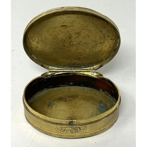 1521 - A gilt metal oval box, the top inset with a blue hardstone plaque, 8 cm wide