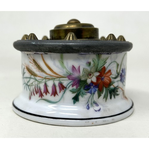 1530 - A 19th century porcelain and brass inkstand, A T & C patent, decorated flowers, 9 cm diameter