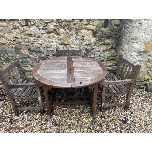 1745 - A teak garden table, 122 cm diameter, and three chairs (4)