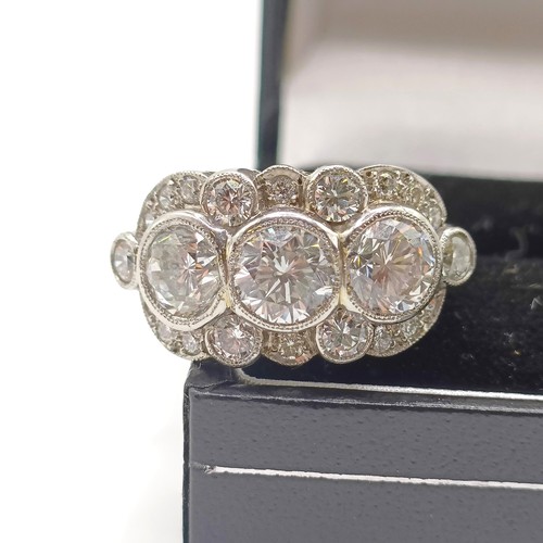 954 - A platinum and diamond ring, with three diamonds within a surround of further diamonds in a rising a... 